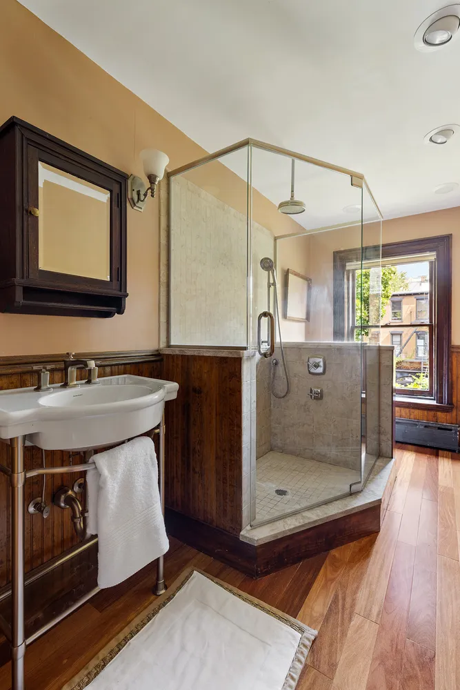 a living room with stainless steel appliances granite countertop a refrigerator a sink dishwasher a dining table and chairs with wooden floor