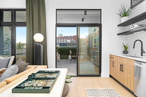 a kitchen with granite countertop a stove a sink and a dining table next to a window