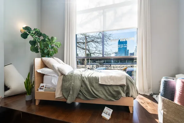 a bed sitting in a bedroom next to a window