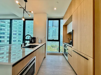 a kitchen with kitchen island a counter top space a sink a refrigerator and wooden floor