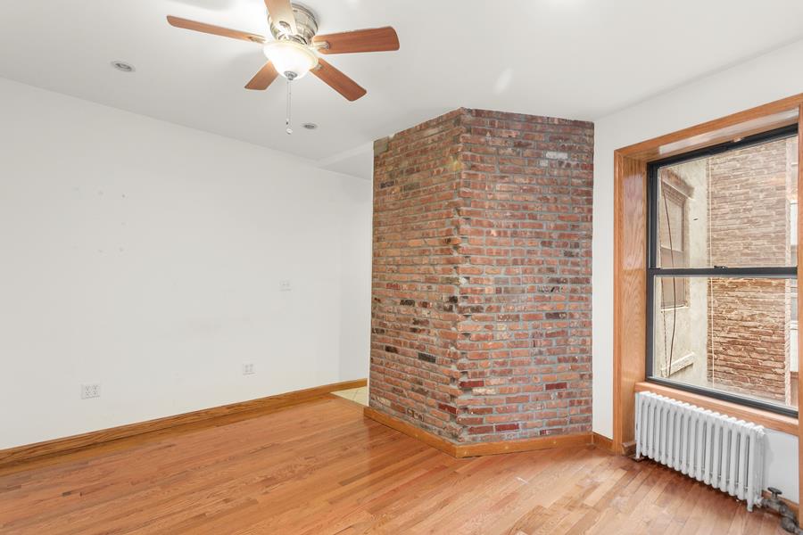 56 MacDougal Street, Unit 16 Manhattan, NY 10012 - Photo 1 of 6 an empty room with wooden floor chandelier fan and windows