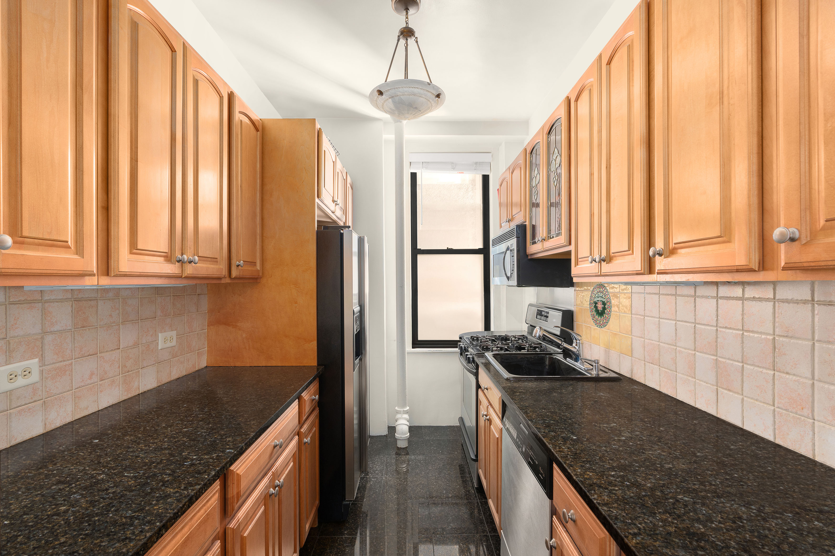 200 West 54th Street, Unit 8G Manhattan, NY 10019 - Photo 5 of 11 a kitchen with stainless steel appliances granite countertop a sink a stove and a refrigerator