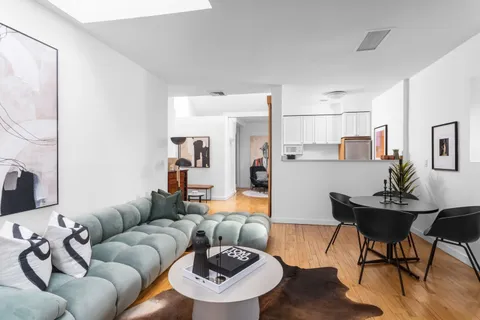 a living room with furniture and kitchen view