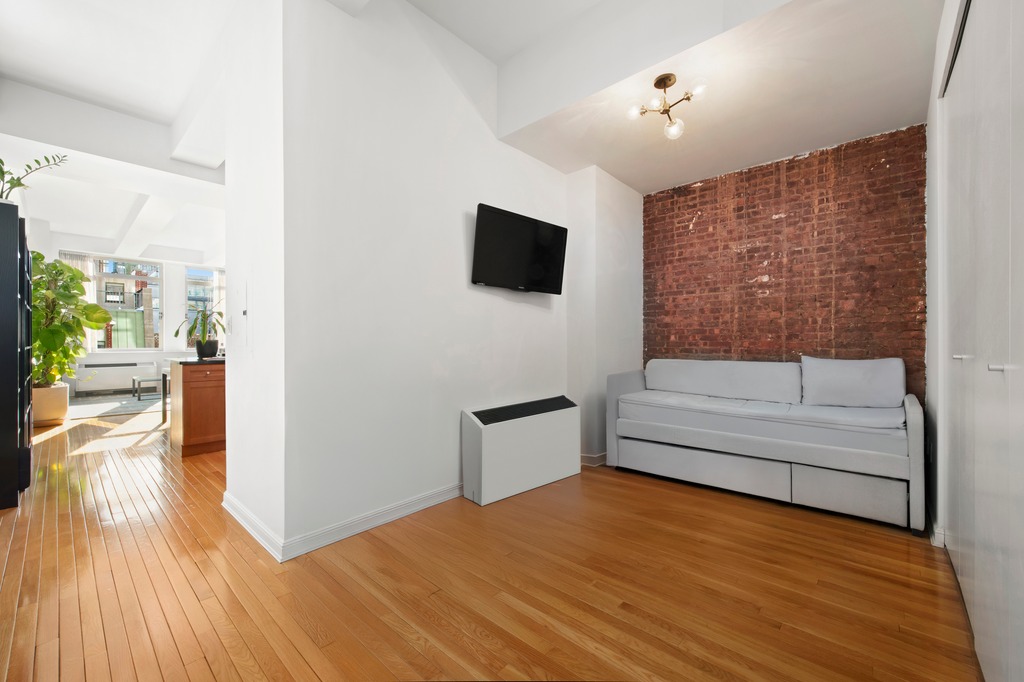 252 7th Avenue, Unit 10T Manhattan, NY 10001 - Photo 8 of 10 a view of a living room and kitchen with a flat screen tv