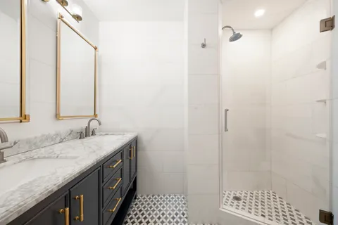 a bathroom with a granite countertop sink a shower and a mirror