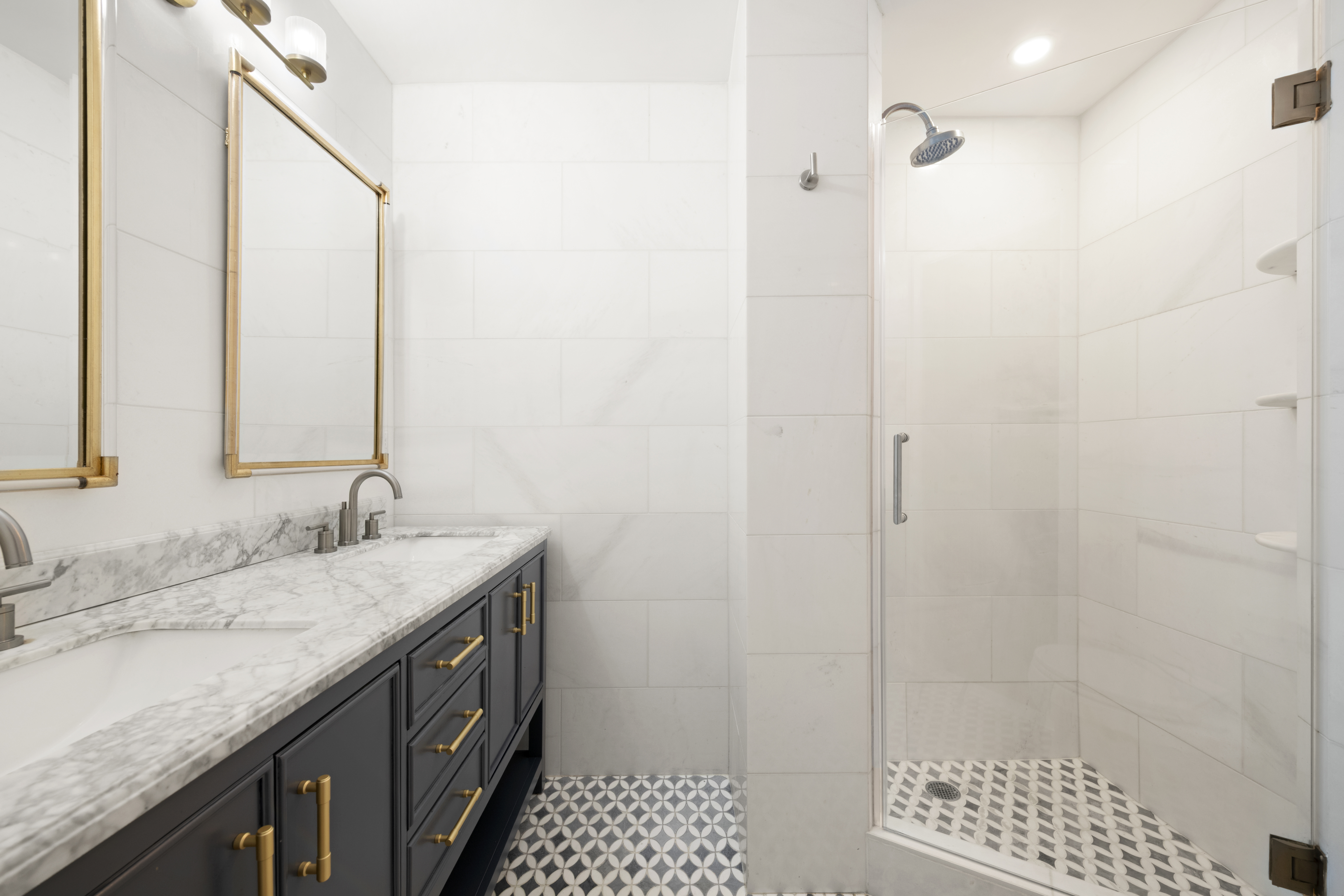 152 East 94th Street, Unit 2J Manhattan, NY 10128 - Photo 10 of 18 a bathroom with a granite countertop sink a shower and a mirror