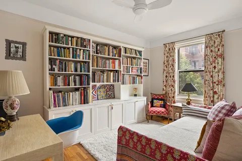 a bedroom with furniture and a book shelf