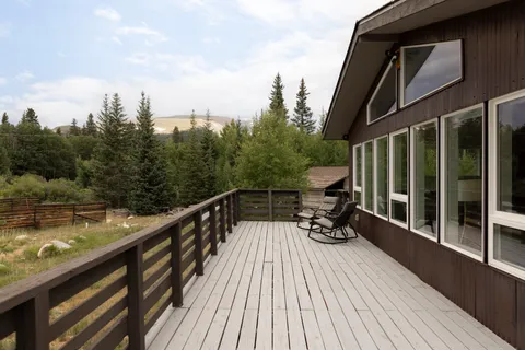 a view of a balcony with two chairs and wooden floor
