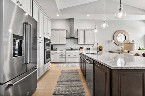 a kitchen with stainless steel appliances granite countertop a sink refrigerator and cabinets