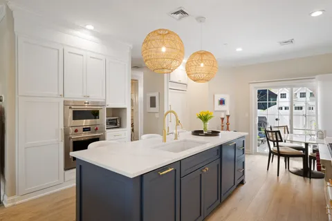 a kitchen with a stove a kitchen island a dining table and chairs