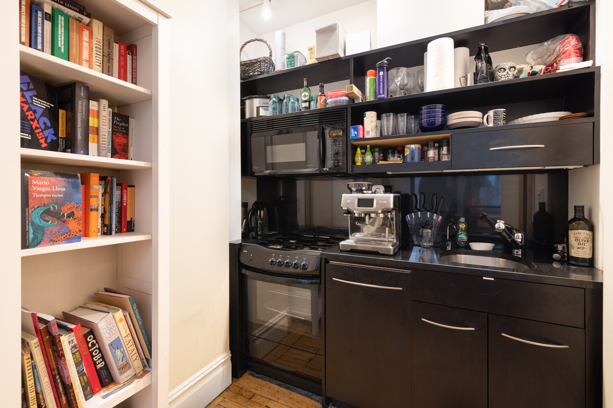 67 Park Avenue, Unit 8E Manhattan, NY 10016 - Photo 4 of 6 a kitchen with stainless steel appliances granite countertop a dining table and bookshelf