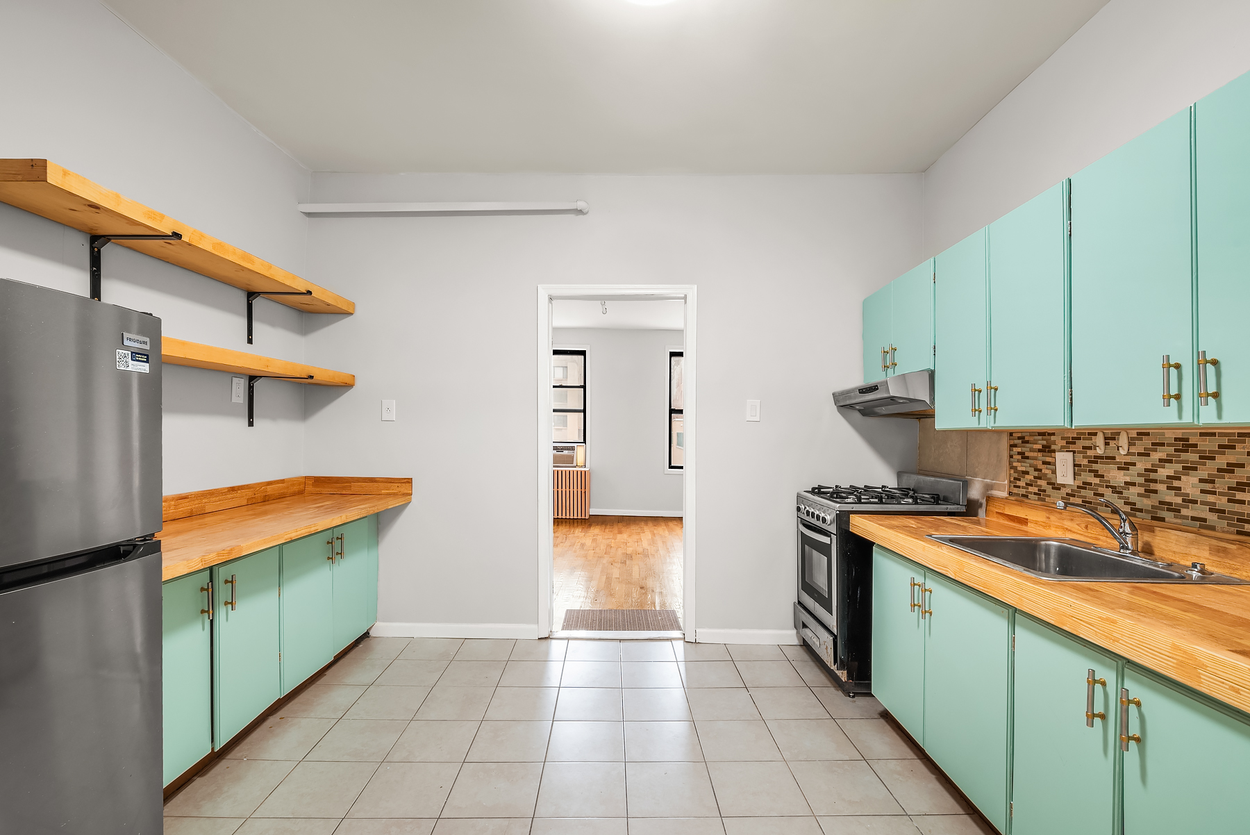 63 East 129th Street, Unit 3 Manhattan, NY 10037 - Photo 2 of 5 a kitchen with stainless steel appliances granite countertop a stove a sink and a refrigerator