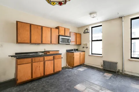 a kitchen with stainless steel appliances granite countertop a stove a sink dishwasher a microwave oven and a refrigerator with wooden cabinets