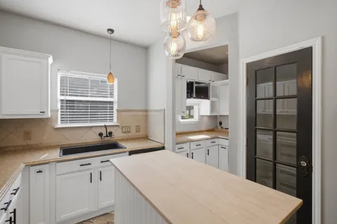 a kitchen with a sink refrigerator and cabinets