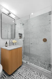 a bathroom with sink mirror and shower