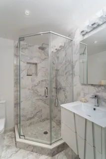 a bathroom with a shower sink and mirror