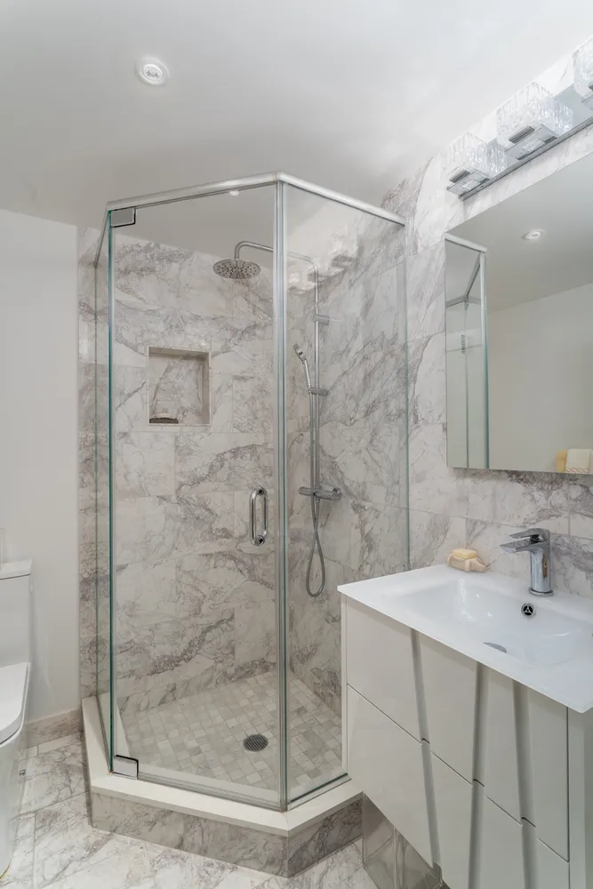 a bathroom with a shower sink and mirror