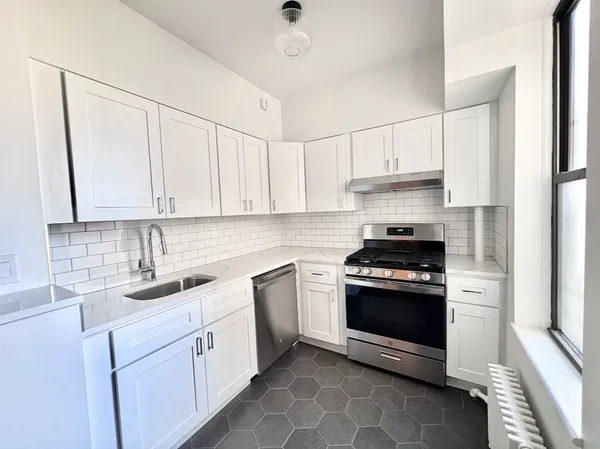a kitchen with white cabinets and appliances