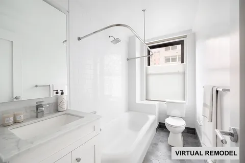 a bath room with a sink vanity mirror and a toilet