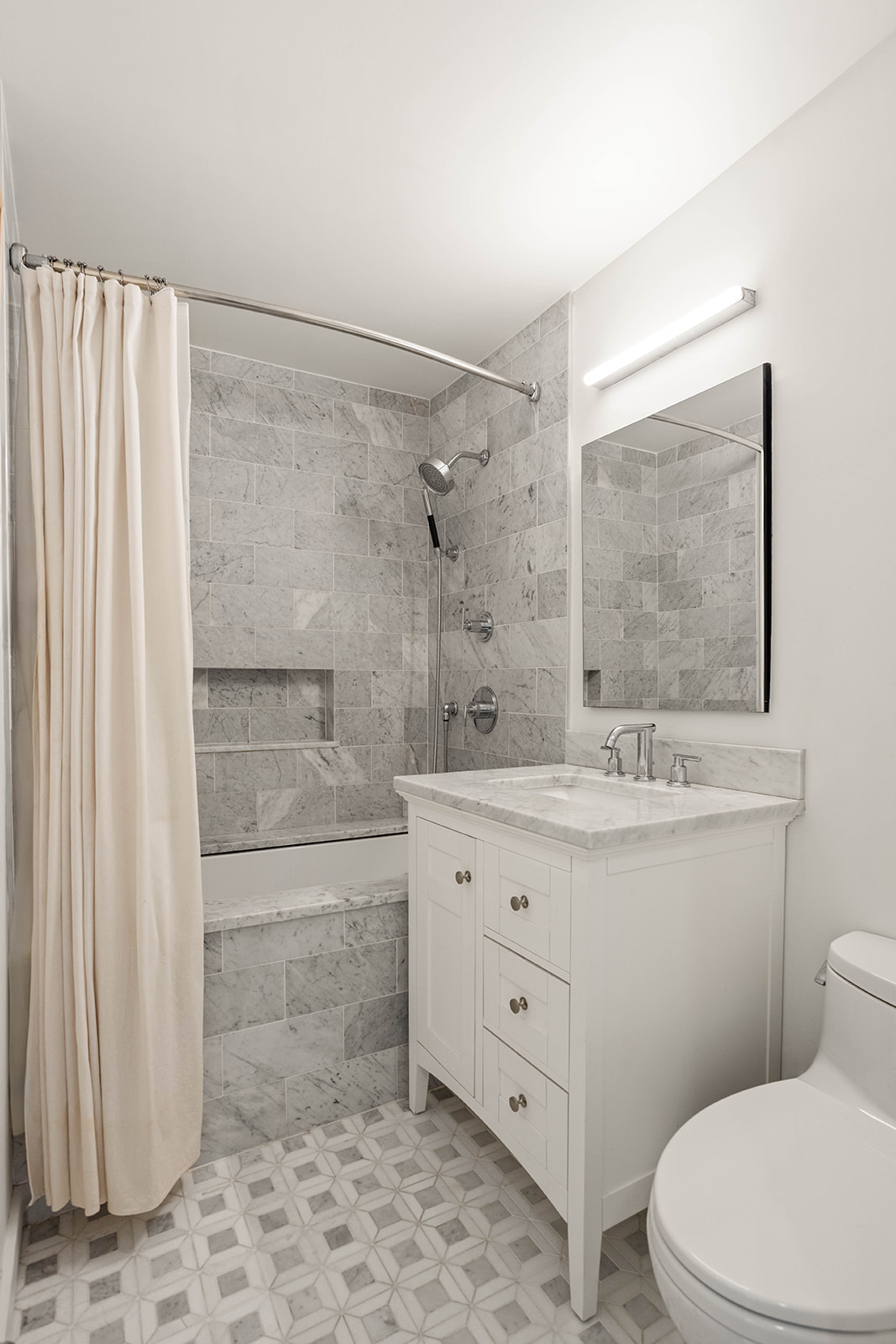 23 Waverly Place, Unit 3Y Manhattan, NY 10003 - Photo 5 of 12 a bathroom with a granite countertop sink toilet a mirror and shower