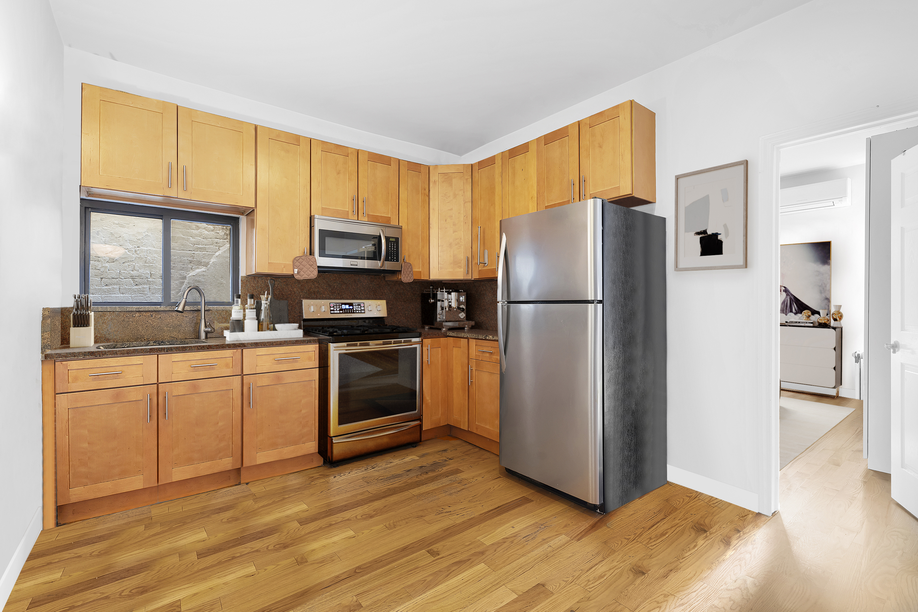 34-57 9th Street Queens, NY 11106 - Photo 4 of 10 a kitchen with granite countertop stainless steel appliances a refrigerator cabinets and a window