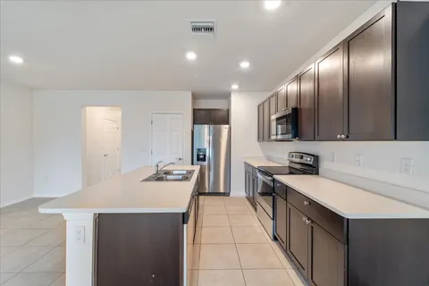 a kitchen with stainless steel appliances a sink stove refrigerator and cabinets