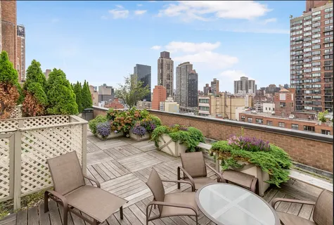 a view of a patio with couches table and chairs and potted plants