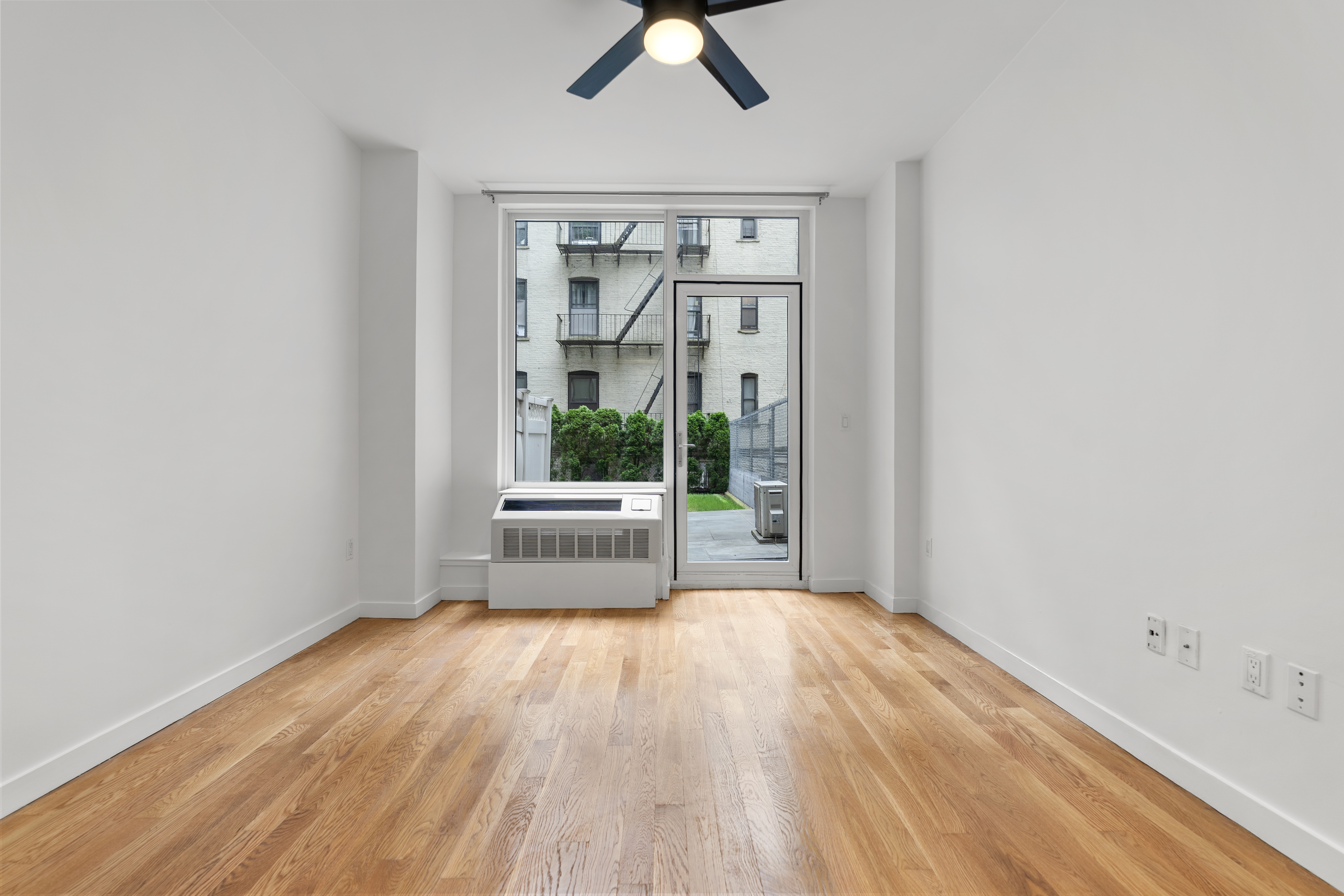 306 West 116th Street, Unit 1C Manhattan, NY 10026 - Photo 2 of 12 a view of a room with wooden floor and iron stairs