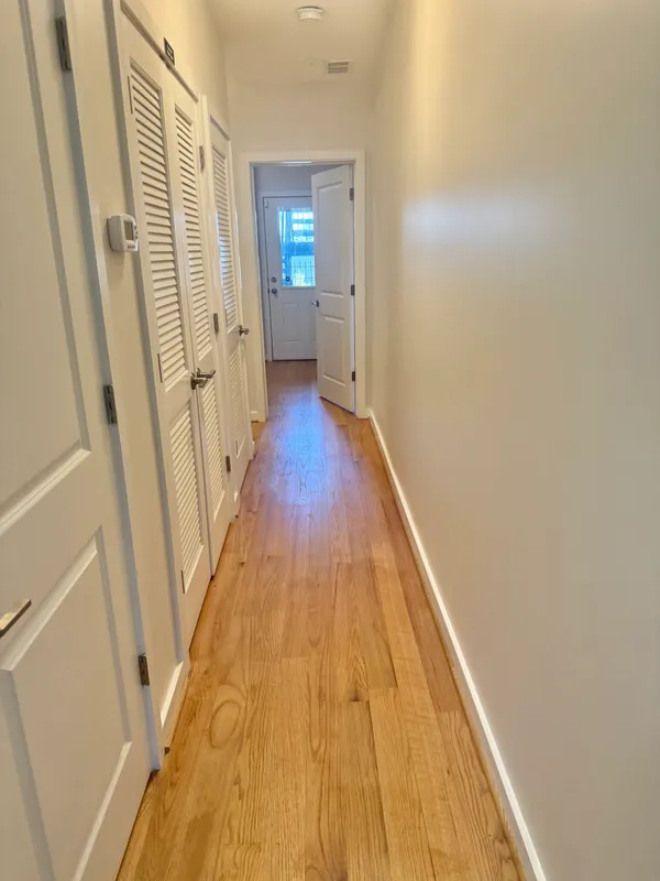 a view of a hallway with wooden floor and staircase