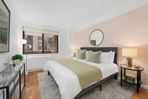 a bedroom with bed and wooden floor