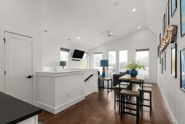 a kitchen with white cabinets and chairs