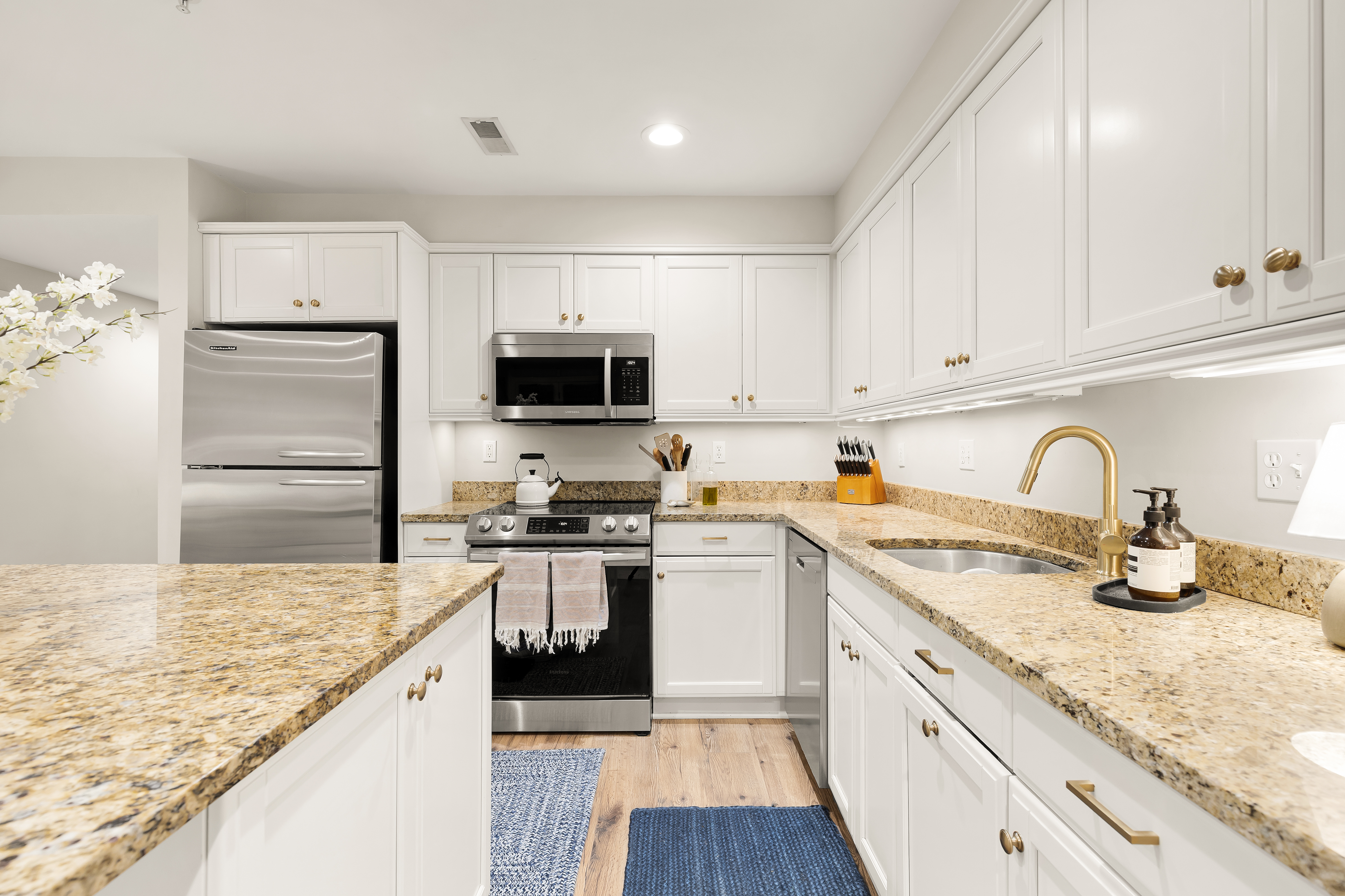 1354 Kenyon Street Northwest, Unit G Washington, DC 20010 - Photo 12 of 35 a kitchen with granite countertop a sink stainless steel appliances and white cabinets