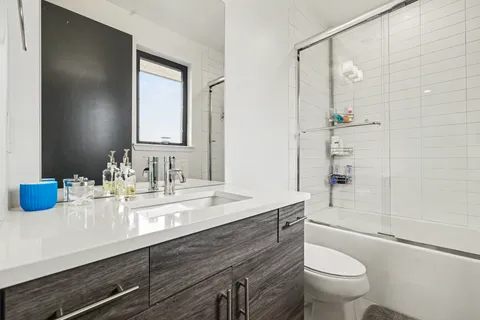 a bathroom with a granite countertop sink toilet and shower