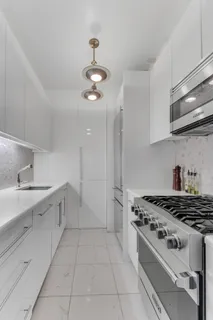 a kitchen with stainless steel appliances a stove a sink and cabinets
