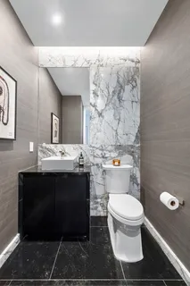 a bathroom with a sink toilet and mirror