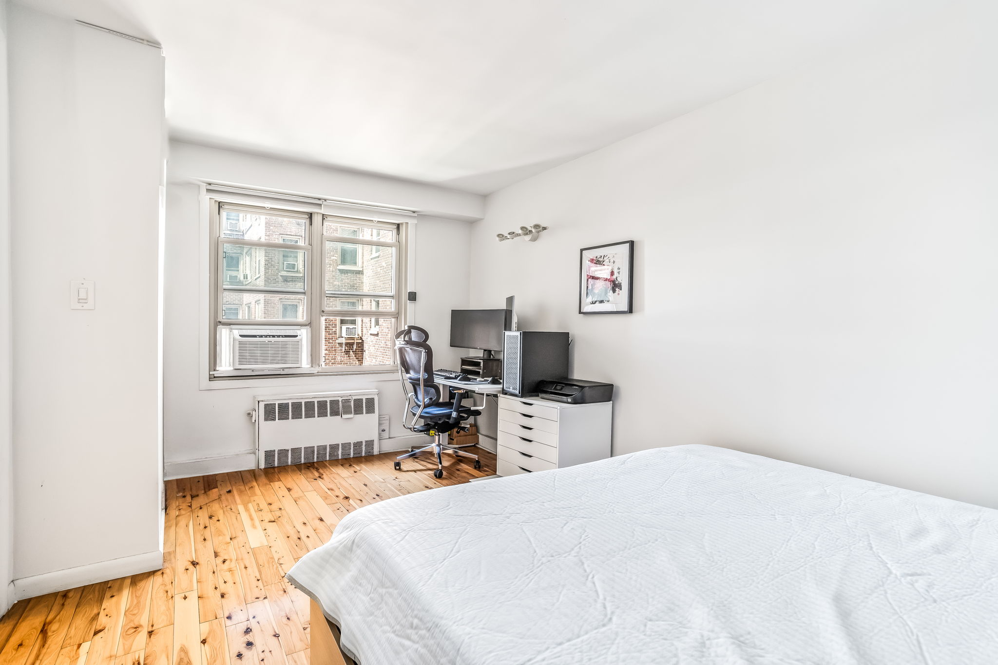 900 West 190th Street, Unit 11J Manhattan, NY 10040 - Photo 8 of 15 a bedroom with a bed and wooden floor