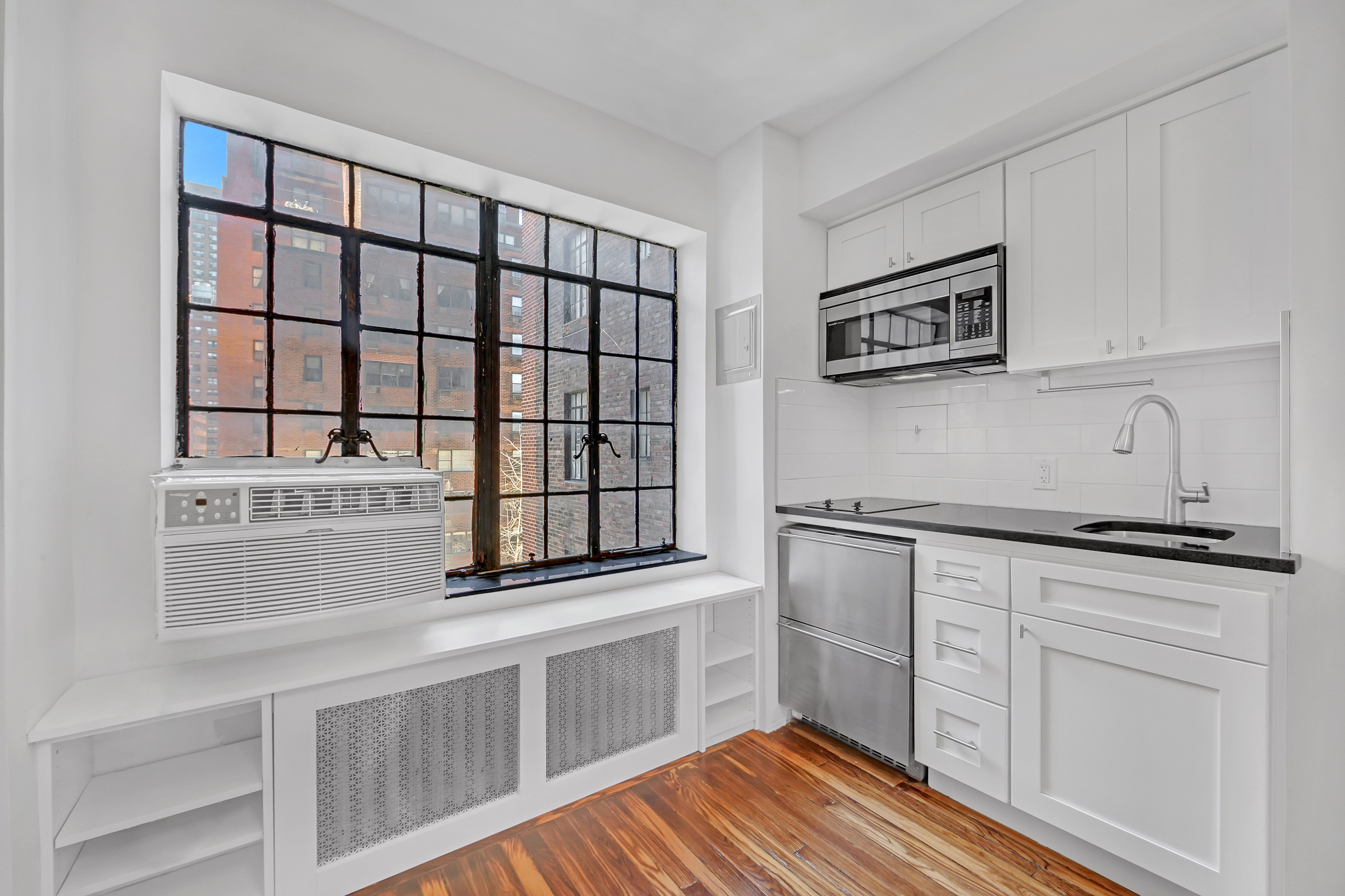 5 Tudor City Place, Unit 608 Manhattan, NY 10017 - Photo 4 of 12 a kitchen with stainless steel appliances a sink and cabinets