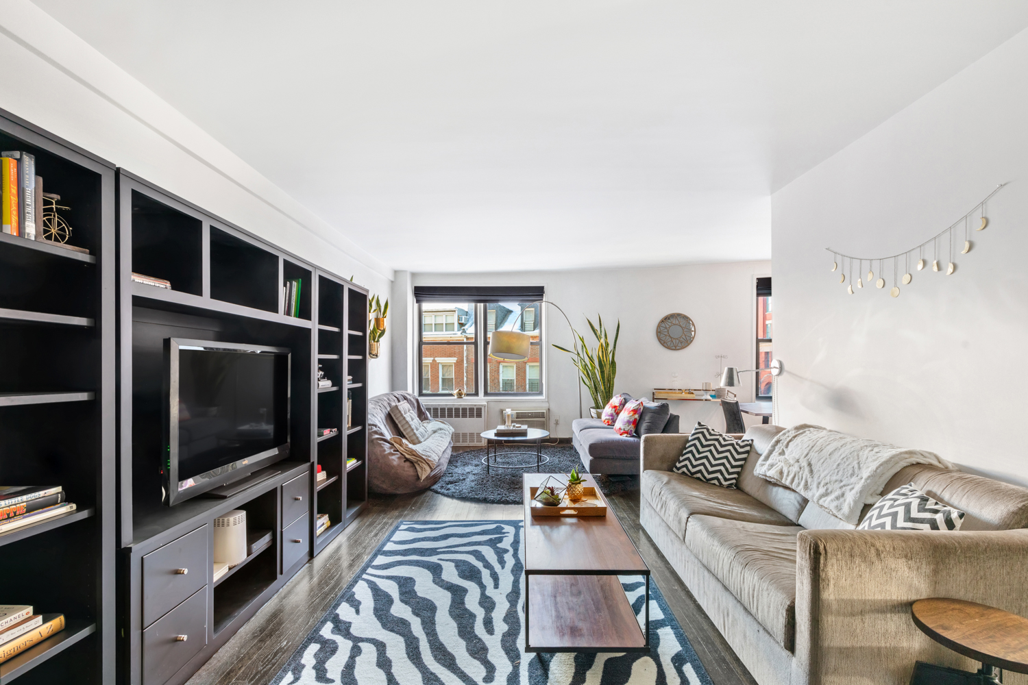 a living room with furniture a flat screen tv and a window