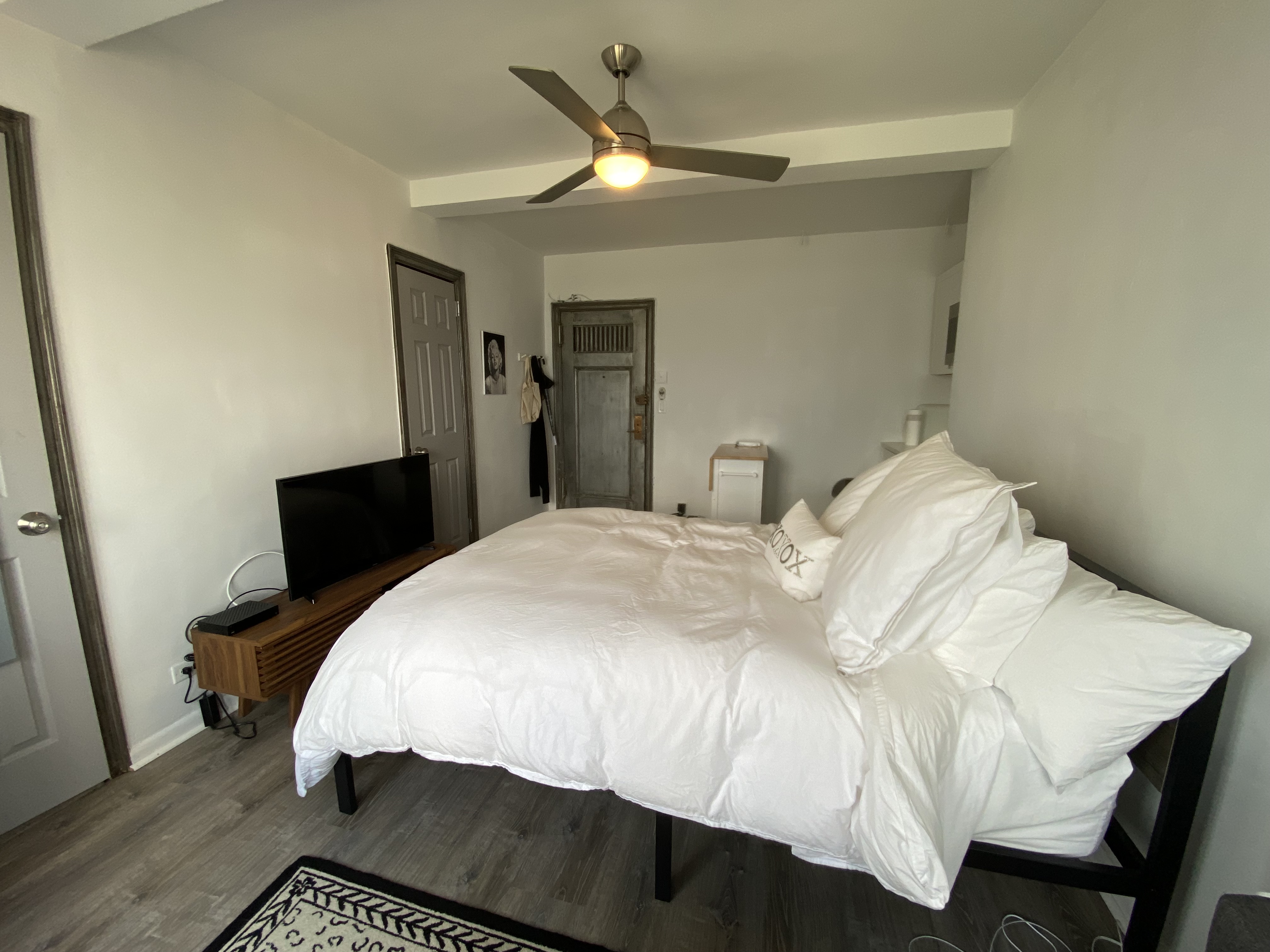 5 Tudor City Place, Unit 1226 Manhattan, NY 10017 - Photo 7 of 10 a bed sitting in a bedroom and a mirror