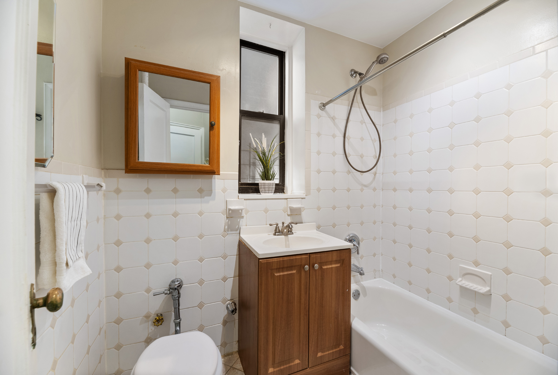 3875 Waldo Avenue, Unit 7P Bronx, NY 10463 - Photo 6 of 8 a bathroom with a sink vanity mirror bathtub shower and toilet