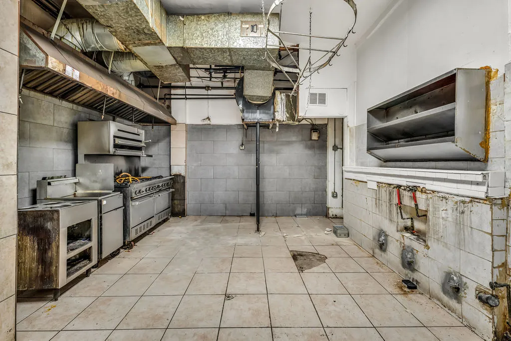a view of a refrigerator in kitchen and an empty room