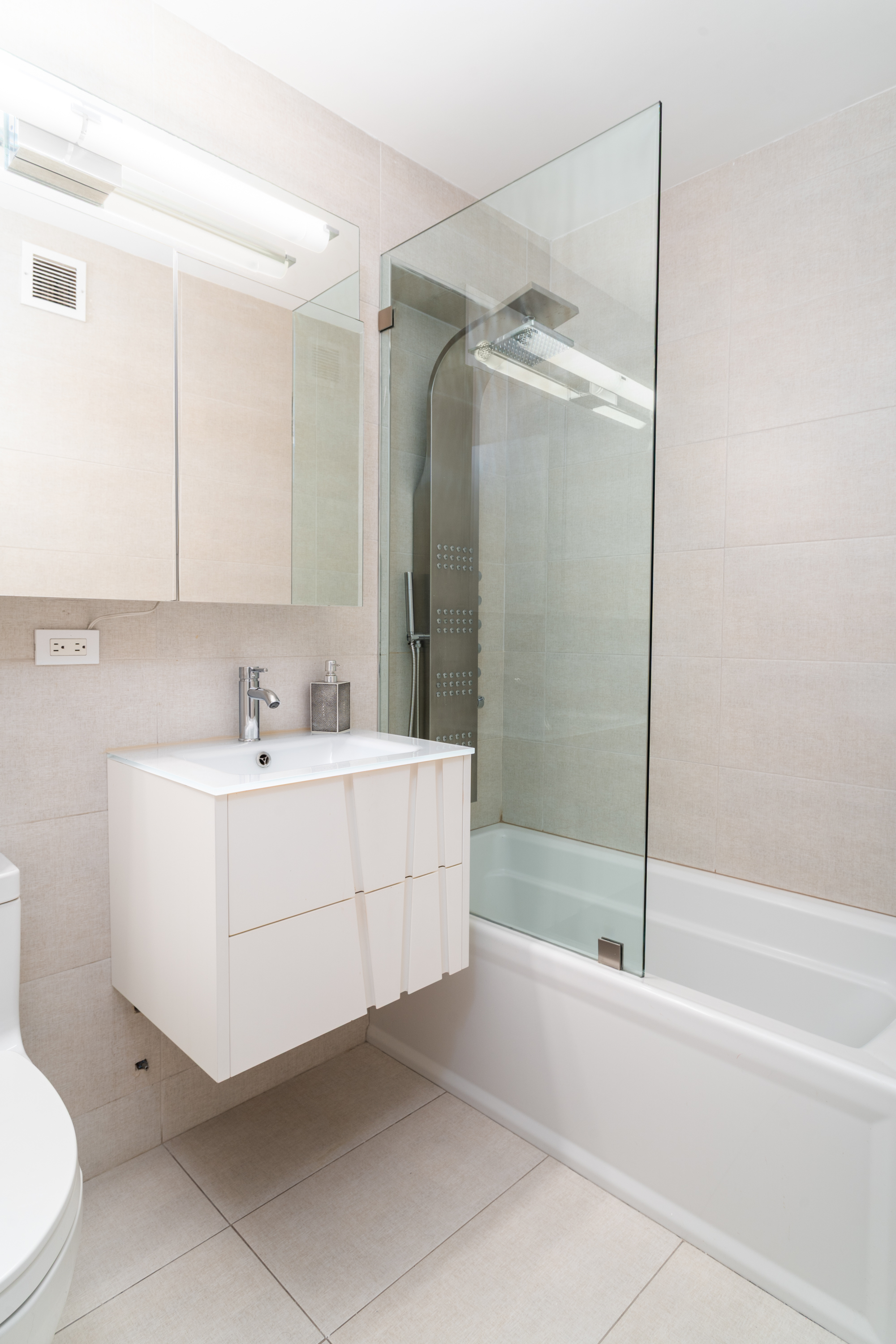 530 East 72nd Street, Unit 7C Manhattan, NY 10021 - Photo 12 of 17 a bathroom with a sink mirror and a bathtub