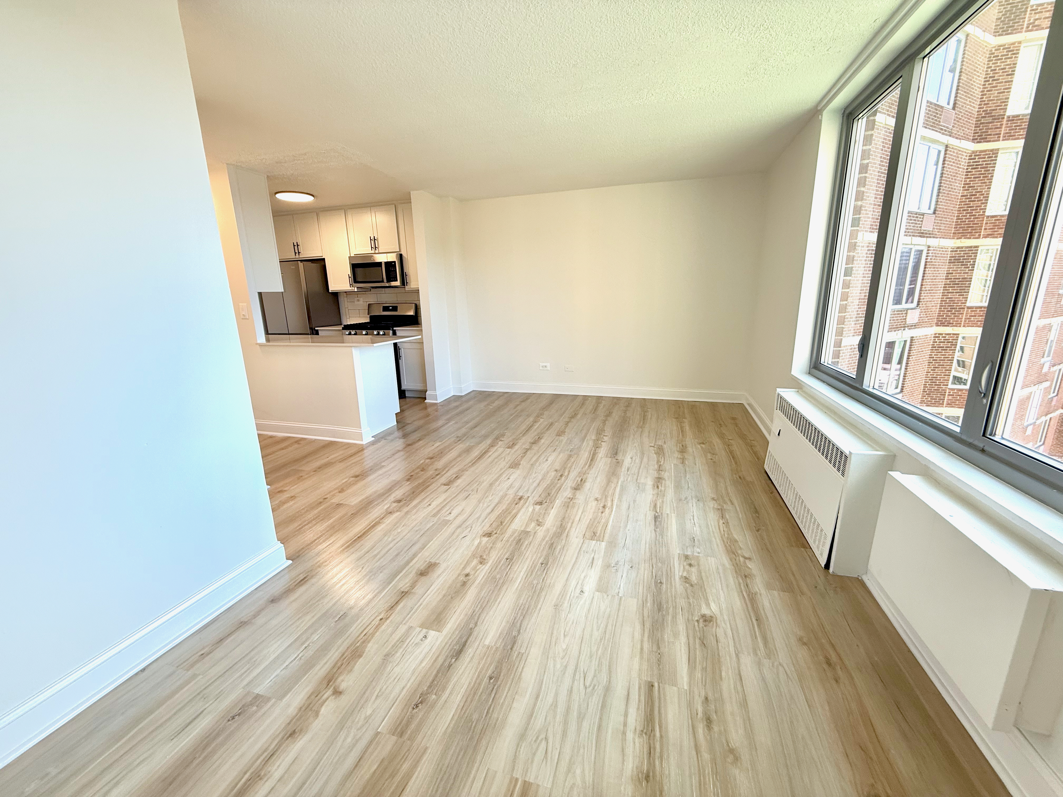 3333 Broadway, Unit D8J Manhattan, NY 10031 - Photo 5 of 22 a view of a kitchen with wooden floor and a sink