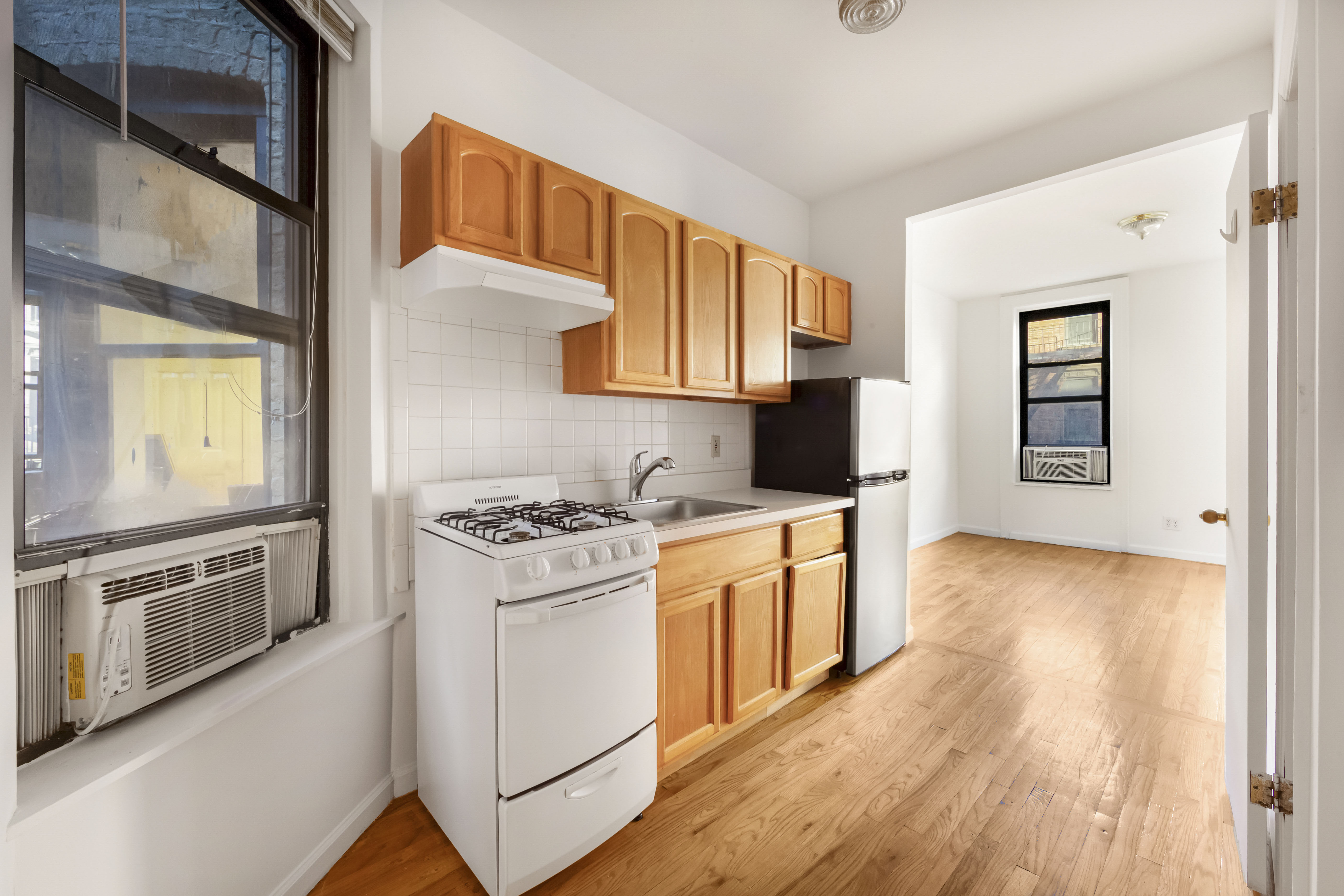 142 Sullivan Street, Unit 12 Manhattan, NY 10012 - Photo 4 of 12 a kitchen with stainless steel appliances granite countertop a stove and a refrigerator