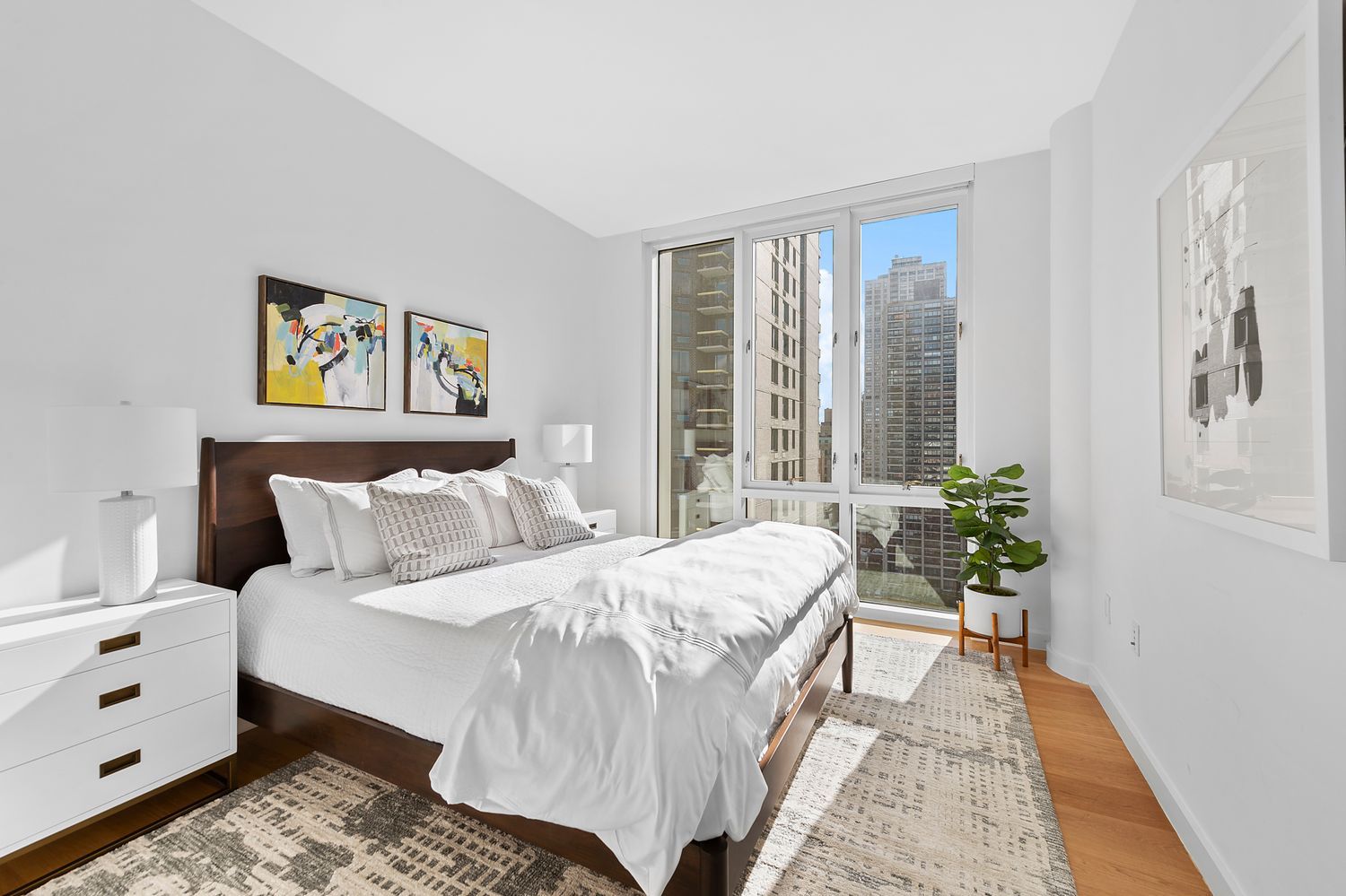 301 East 61st Street, Unit 16A Manhattan, NY 10065 - Photo 16 of 17 a bedroom with a large bed and a potted plant