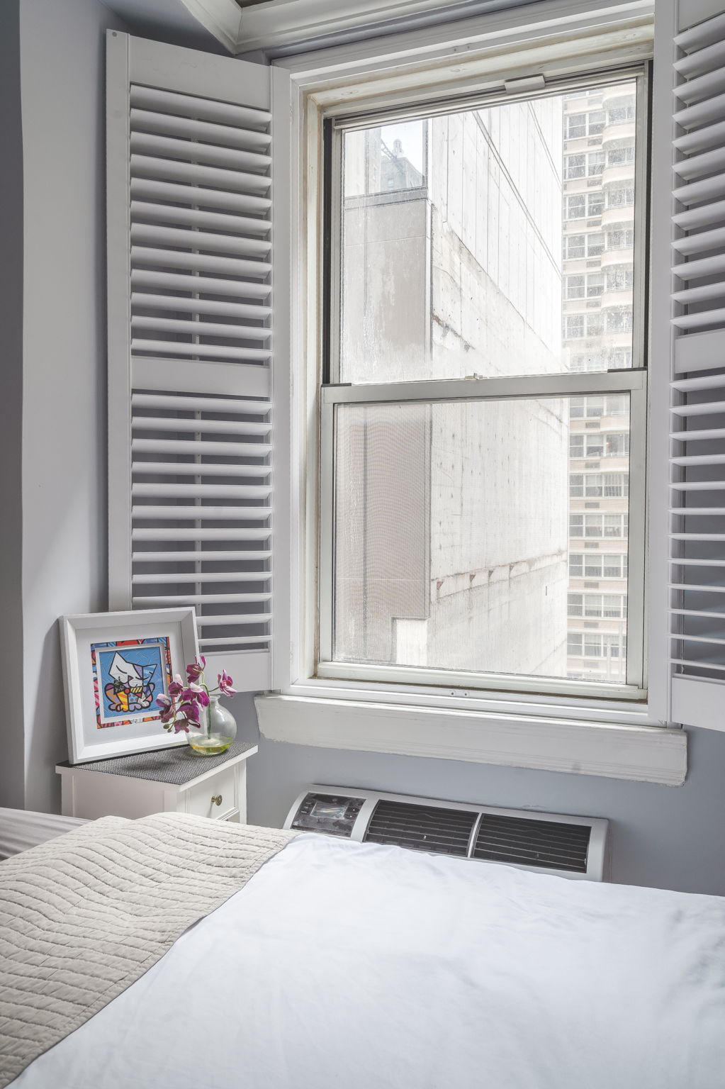 155 East 49th Street, Unit 10E Manhattan, NY 10017 - Photo 7 of 12 a bedroom with a bed and a window