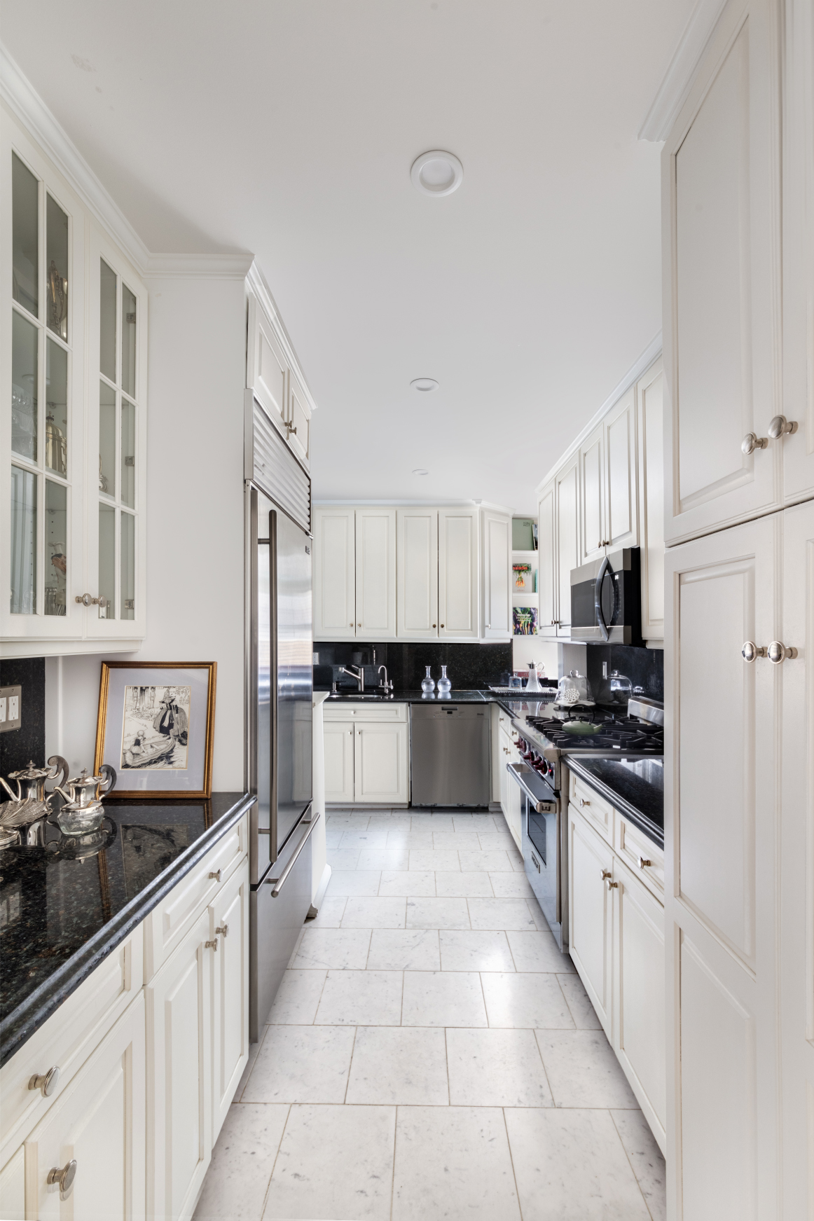 65 East 96th Street, Unit 15D Manhattan, NY 10128 - Photo 8 of 13 a large kitchen with stainless steel appliances lots of counter space and a sink