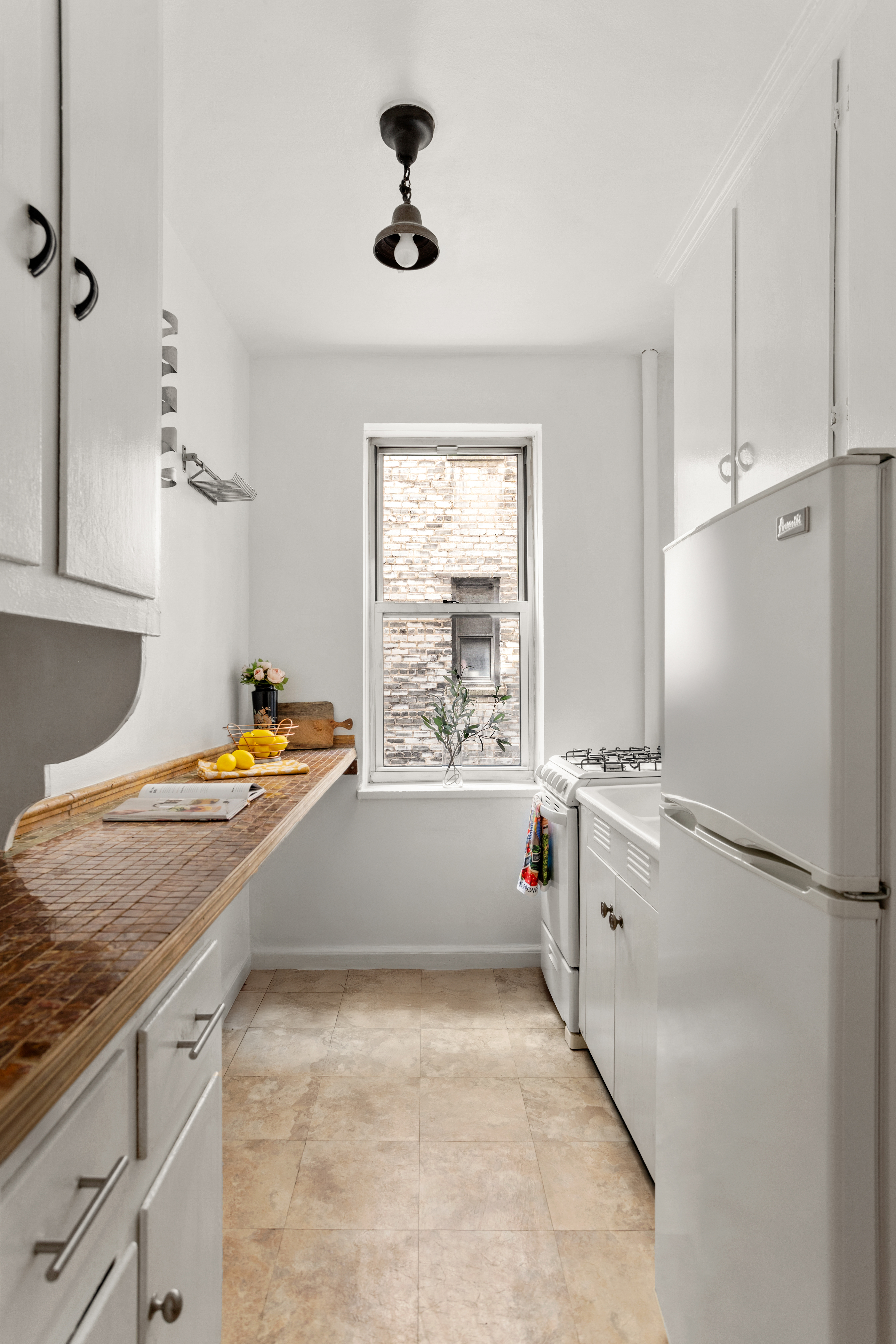 303 East 37th Street, Unit 3B Manhattan, NY 10016 - Photo 8 of 16 a kitchen with stainless steel appliances a stove a sink and a refrigerator