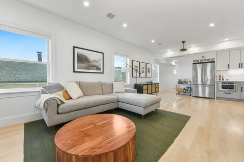 a living room with furniture and a wooden floor