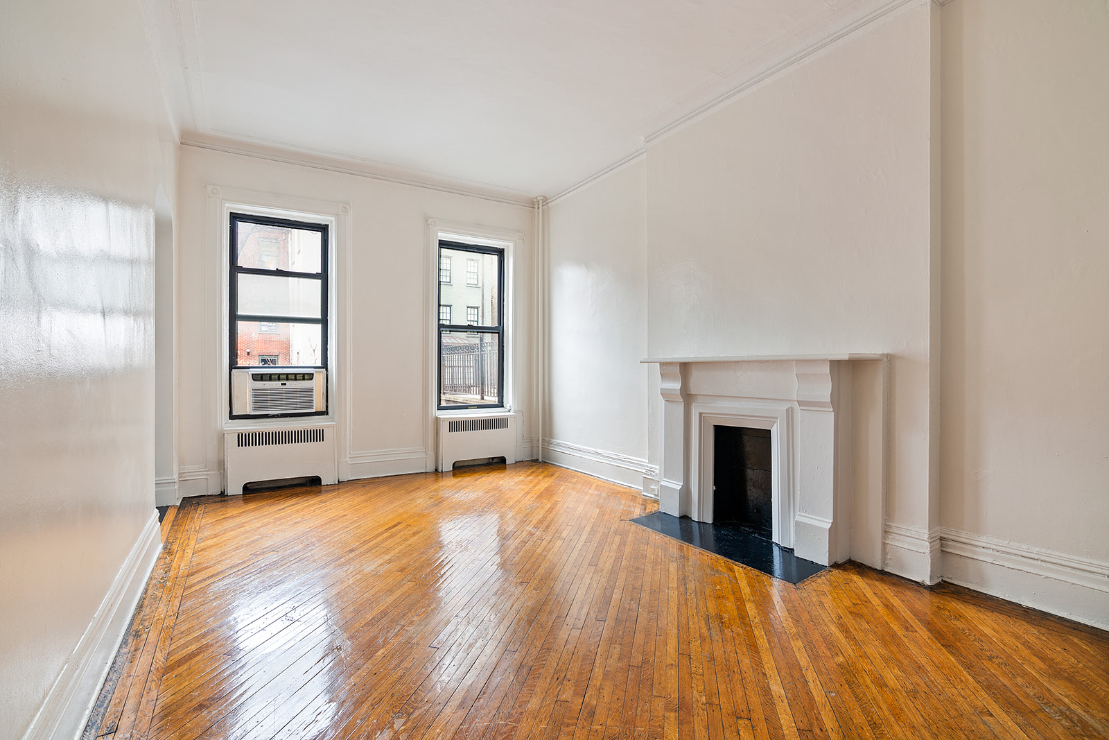 65 East 80th Street, Unit 3B Manhattan, NY 10075 - Photo 1 of 5 an empty room with windows and fireplace